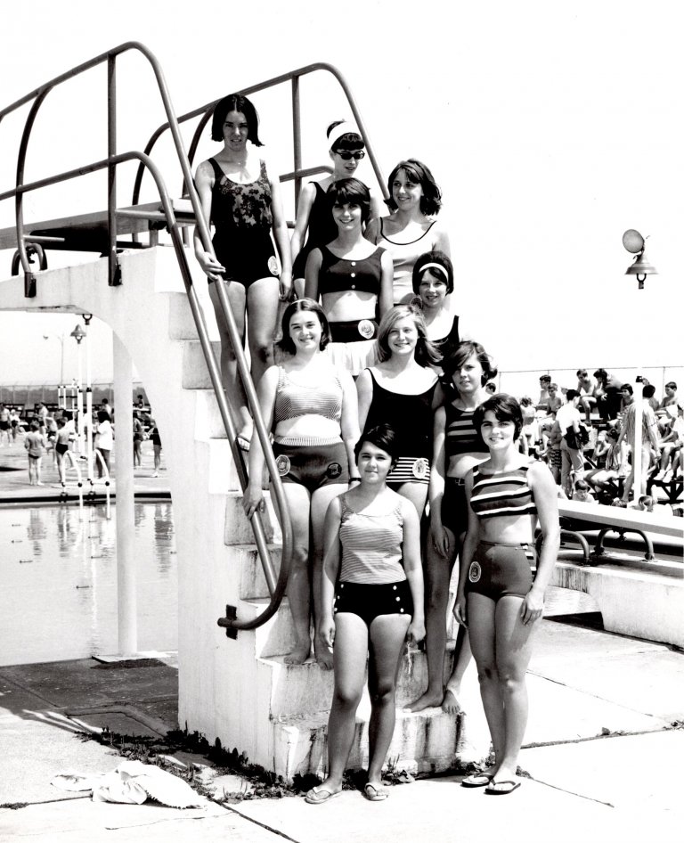 A group of female swimmers next to the diving board A group of female swimmers next to the diving board